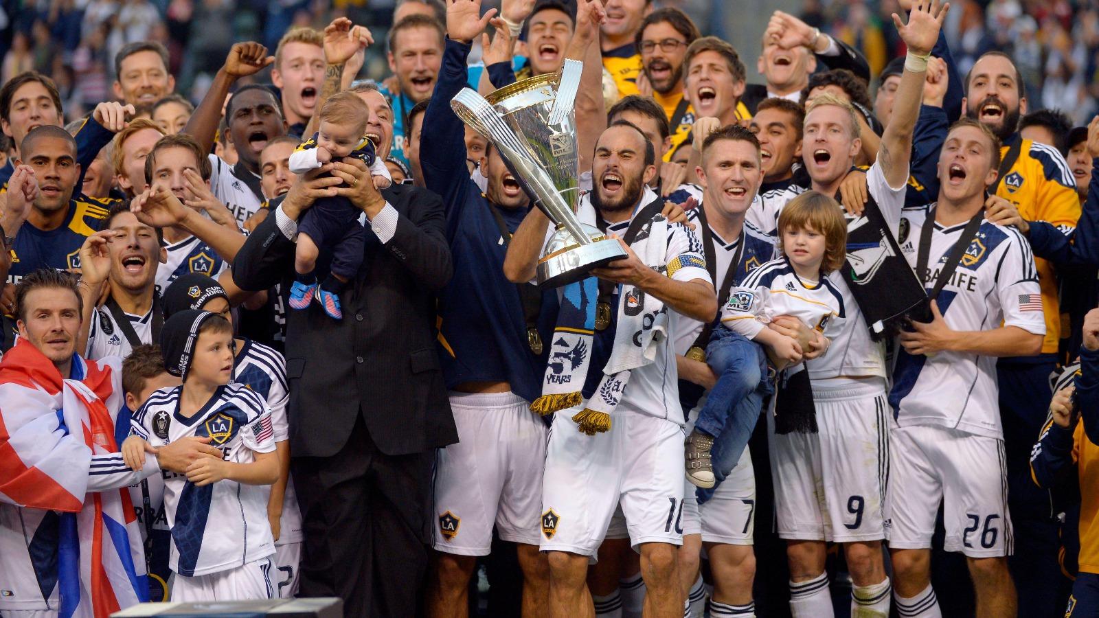 Los Angeles Galaxy, players including Landon Donovan holding the trophy, and David Beckham, front left, celebrate after defeating the the Houston Dynamo 3-1 in the MLS Cup championship soccer game, Saturday, Dec. 1, 2012, in Carson, Calif.